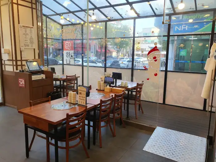 매장 내부의 전반적인 모습을 담은 사진. 통유리창 너머로 거리 풍경이 보이며, 따뜻한 조명이 설치된 아늑한 공간이다.