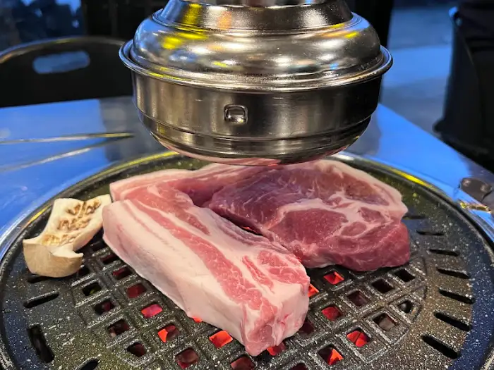 불판 위에 올려진 흑돼지 근고기와 버섯