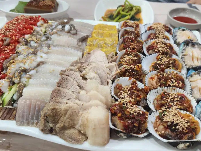 다양한 종류의 해산물과 고기 요리가 조화롭게 담긴 플레이트