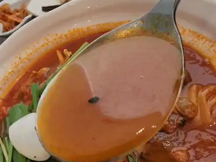 짬뽕 국물 한 숟갈을 뜨는 모습