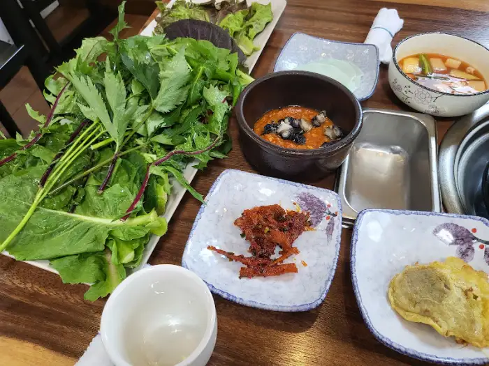 먹음직스러운 제육볶음과 함께 신선한 쌈 채소가 푸짐하게 담겨 나온 모습.