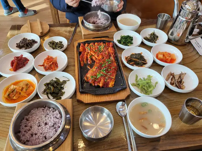 더덕구이와 밥, 그리고 여러 반찬이 놓인 테이블