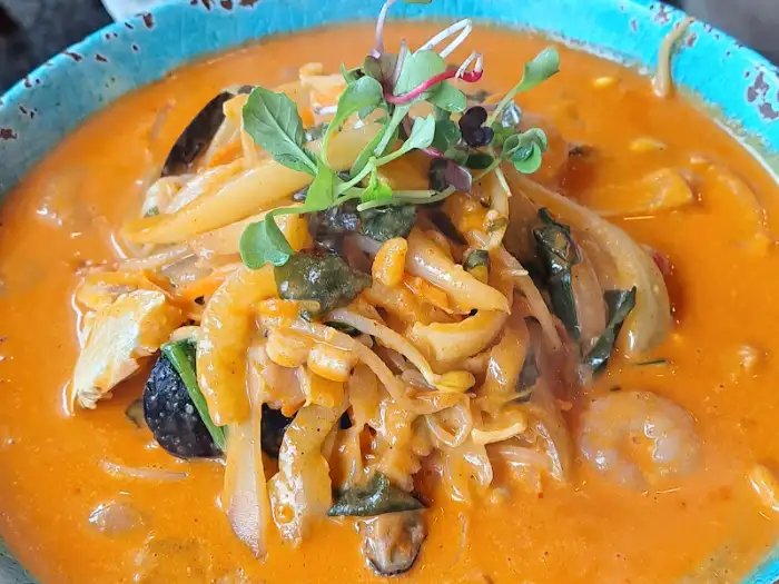 짬뽕 국물이 자작하게 담겨 있고 다양한 재료가 섞여 있는 모습