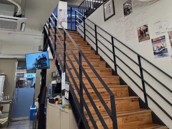 계단을 올라가는 모습과 계단 벽에 붙은 사진들