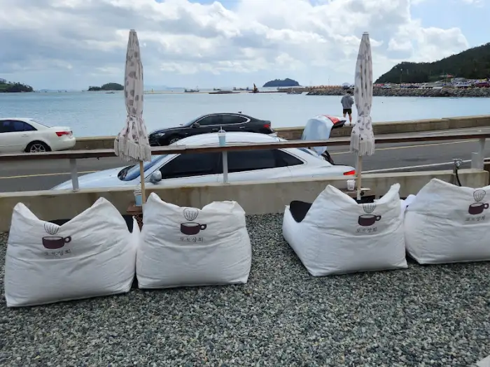 카페 앞 해변가에 놓인 빈백 소파와 바다 풍경