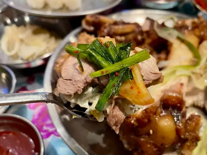 족발 한 점을 소스에 찍어 먹는 모습