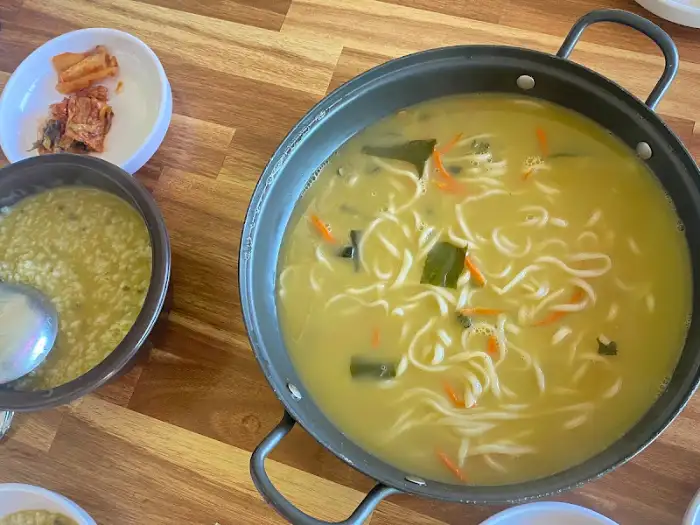 식탁 위에 놓인 보말 칼국수 냄비와 보말죽 그릇
