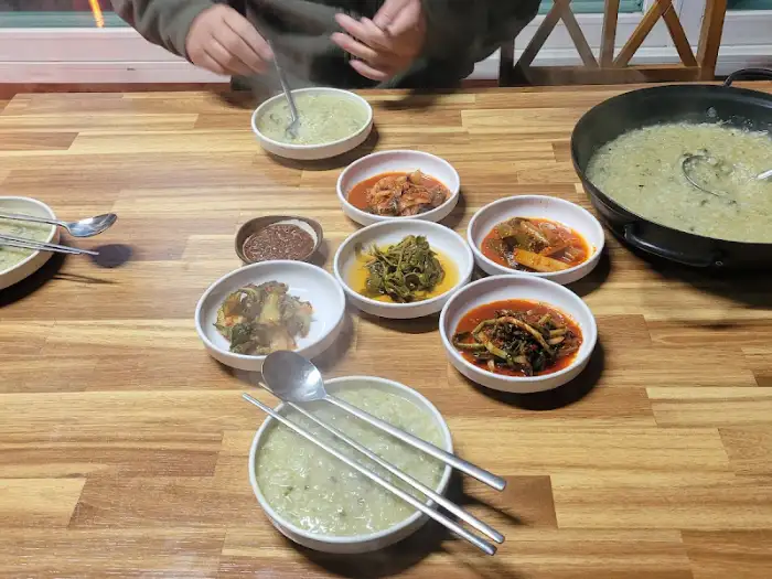 테이블 위 여러 반찬과 죽, 칼국수