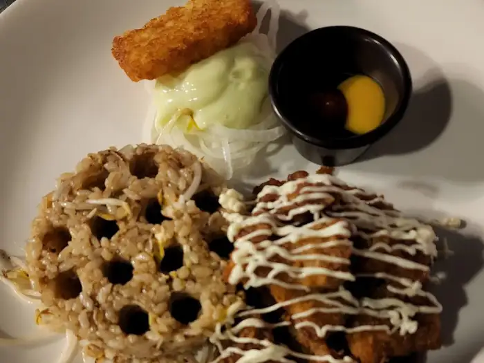 바삭하게 튀겨진 돈까스 조각과 볶음밥, 그리고 곁들임 찬이 접시에 담겨 있다.