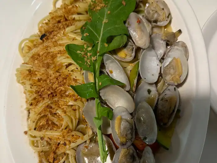 봉골레 파스타의 클로즈업 샷, 신선한 조개와 면발, 녹색 채소가 조화로움