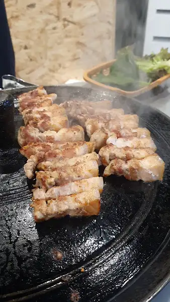 자욱한 연기 속에서 구워지는 삼겹살