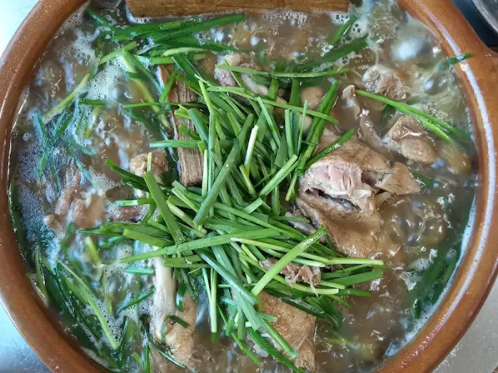 옻오리백숙 국물 속 오리 건더기와 부추