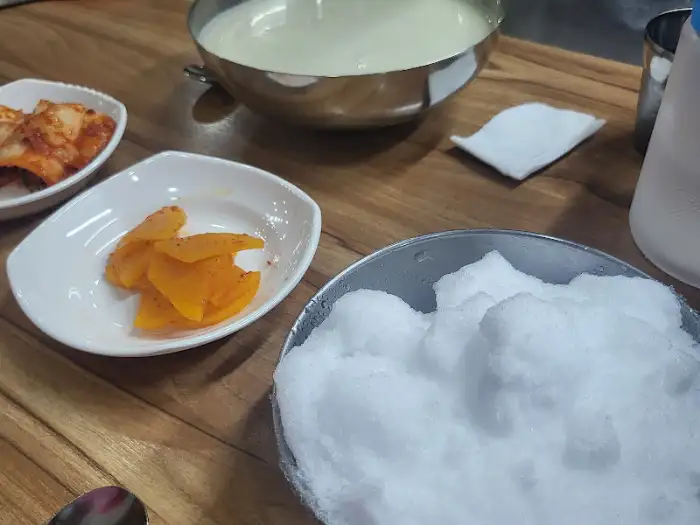 테이블에 놓인 콩물국수와 밑반찬, 그리고 얼음 덩어리