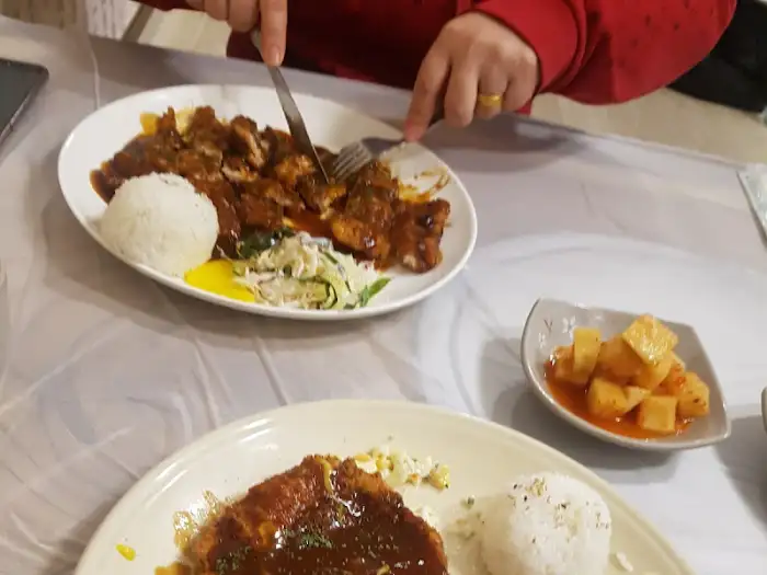 불판 위에서 구워지고 있는 고기와 곁들여 나오는 밥, 샐러드.