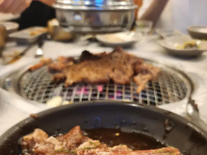 불판 위에서 맛있게 구워지고 있는 고기.