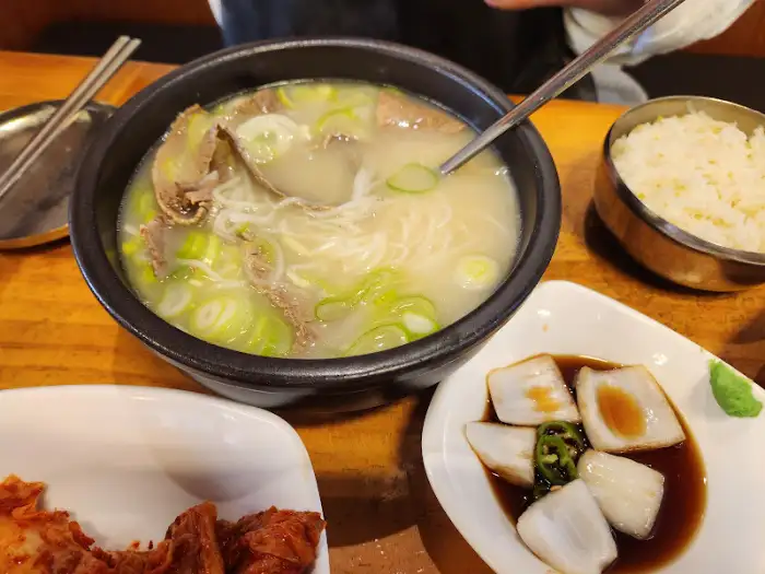 따로국밥 한 그릇. 붉은 국물에 선지, 고기, 파가 푸짐하게 담겨 있다.