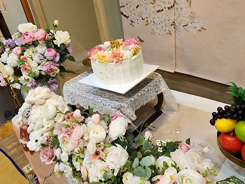 꽃 장식과 레이스 테이블보가 어우러진 아름다운 케이크