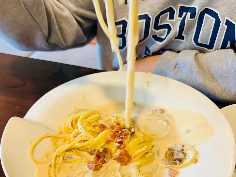 크림 소스가 듬뿍 뿌려진 파스타를 들어올리는 모습