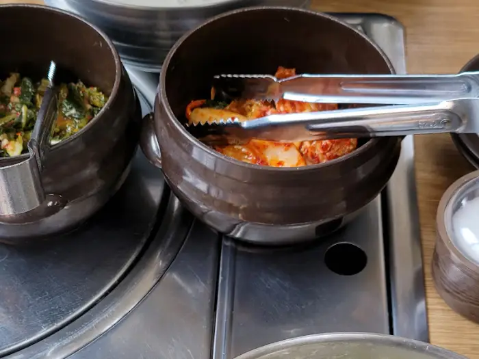 김치가 담긴 그릇과 집게.