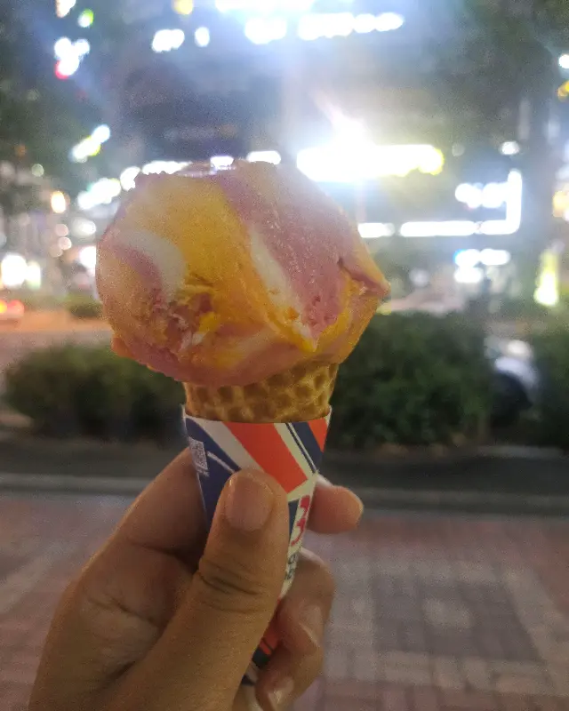 콘 아이스크림을 들고 밤거리를 걷는 모습