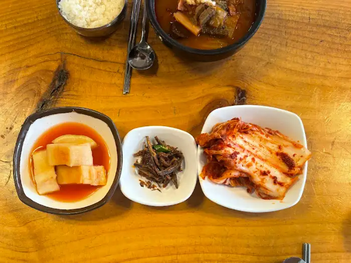 설렁탕과 곁들임 반찬. 깍두기, 멸치볶음, 김치 등이 보인다.