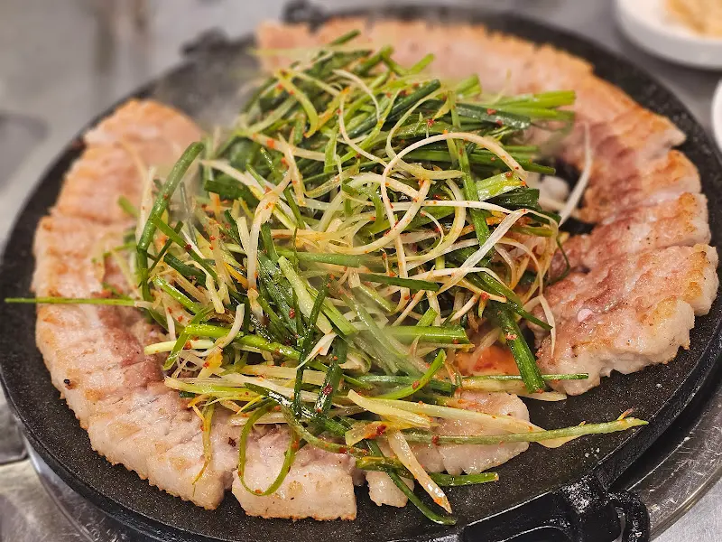 노릇하게 익어가는 삼겹살과 부추의 조화