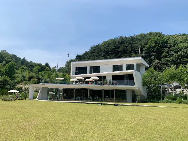 넓은 잔디밭을 배경으로 한 카페 건물 전경