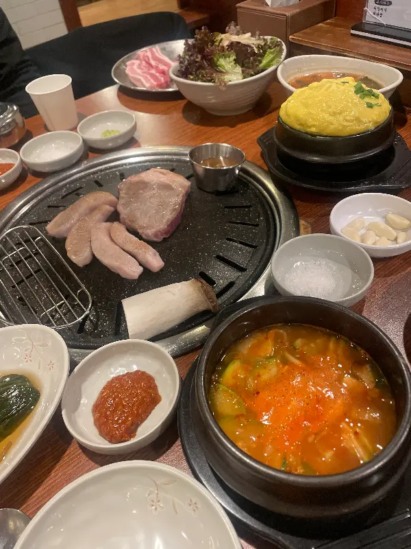 다양한 밑반찬과 계란찜, 된장찌개가 함께 차려진 푸짐한 한 상