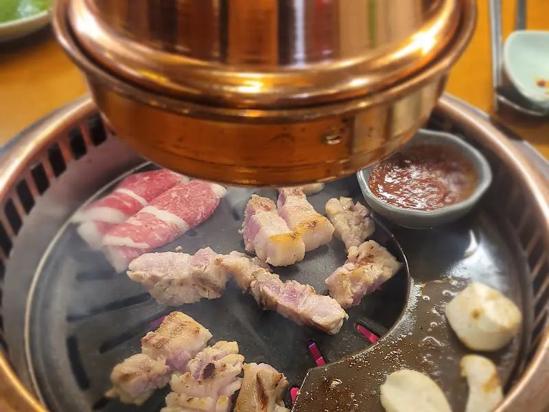 초벌되어 나온 삼겹살과 항정살이 석쇠 위에서 익어가는 모습