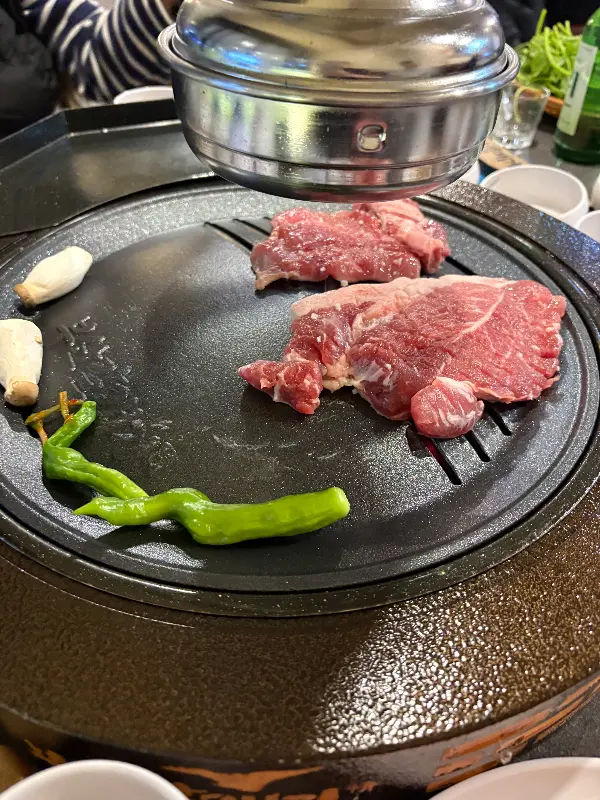 숯불 위에 올려진 신선한 갈매기살과 버섯, 고추