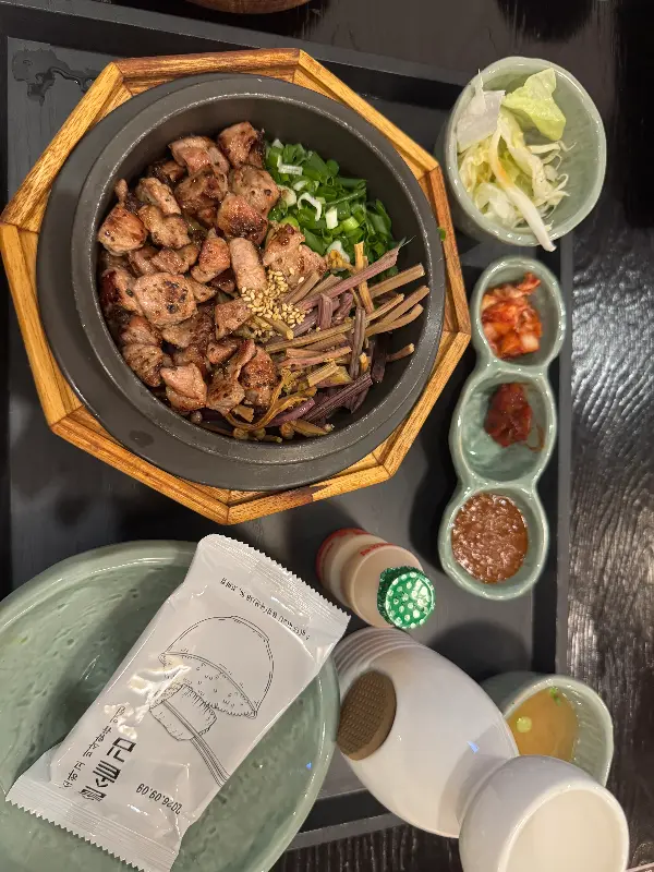 스테이크 솥밥의 뚜껑을 열자, 스테이크와 밥알, 그리고 다양한 고명이 조화롭게 어우러져 있다.