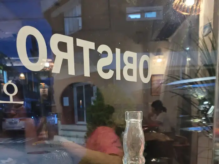 갓 구운 화덕 피자 클로즈업, 신선한 루꼴라와 햄, 치즈가 풍성하게 올라간 모습