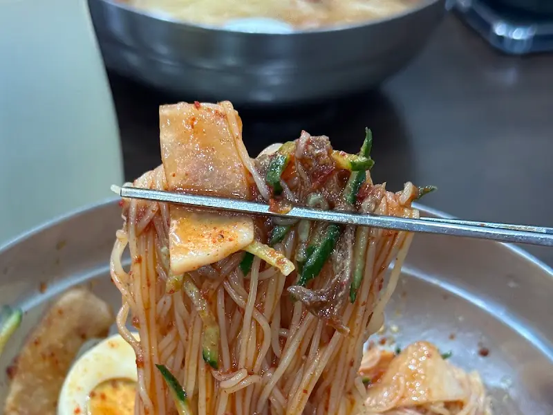 젓가락으로 집어 올린 비빔밀면의 면발