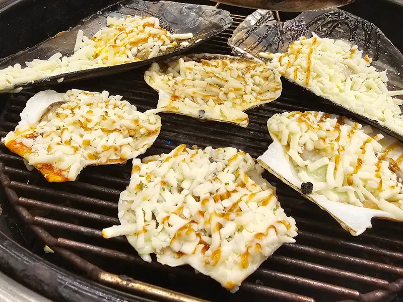 불판 위에서 익어가는 치즈 조개구이