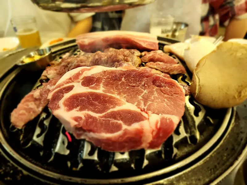 숯불 위에 올려진 두툼한 목살과 버섯