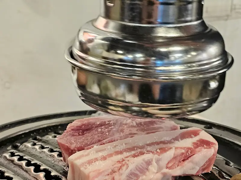 숯불 위에서 익어가는 두툼한 고기