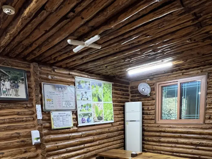 통나무로 인테리어된 식당 내부 모습입니다. 벽면과 천장이 모두 통나무로 되어 있습니다.