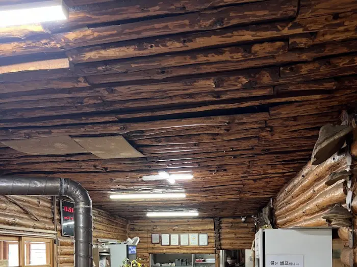 통나무로 마감된 식당 천장과 벽면의 디테일이 보입니다.