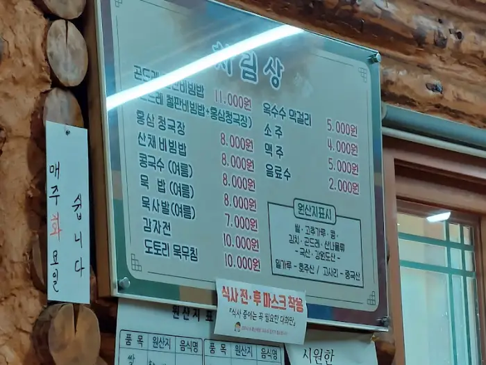 식당의 메뉴판 사진입니다. 곤드레 비빔밥, 청국장, 감자전 등의 가격이 적혀 있습니다.