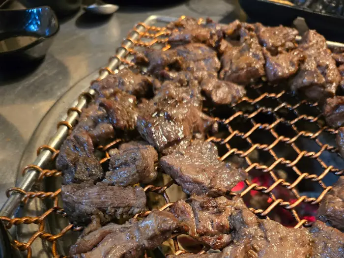 풍성하게 차려진 식탁 위, 구워지는 고기