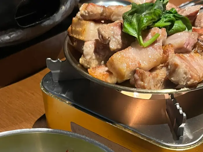 금속 불판 위에서 익어가고 있는 삼겹살 덩어리들