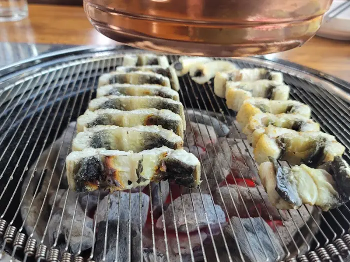 숯불 위에서 노릇하게 익어가는 장어 조각들