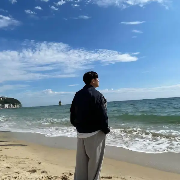 해변에서 바다를 바라보는 남자의 뒷모습