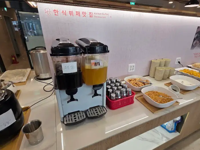 음료 디스펜서와 각종 소스, 반찬들이 진열된 모습