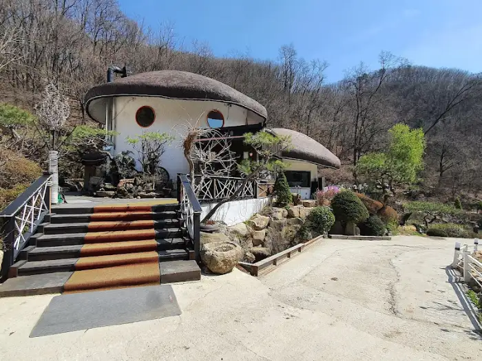 숲속 언덕에 자리 잡은 버섯 모양의 독특한 건물