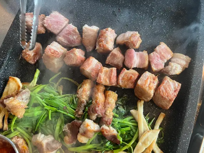 노릇하게 구워지는 숙성 돼지고기와 미나리