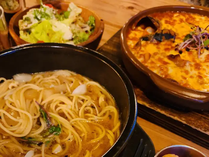 봉골레 파스타, 샐러드, 그리고 치즈가 덮인 요리