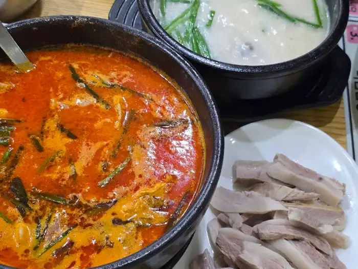 큼직한 뚝배기에 담긴 국밥과 수육 접시