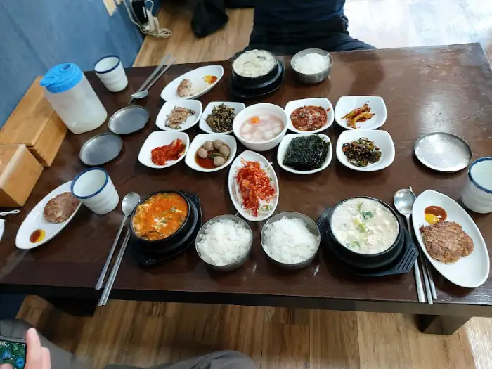 푸짐하게 차려진 순두부찌개, 밥, 두부 스테이크와 여러 반찬들