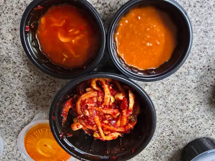 세 가지 종류의 소스가 담긴 검정색 용기들